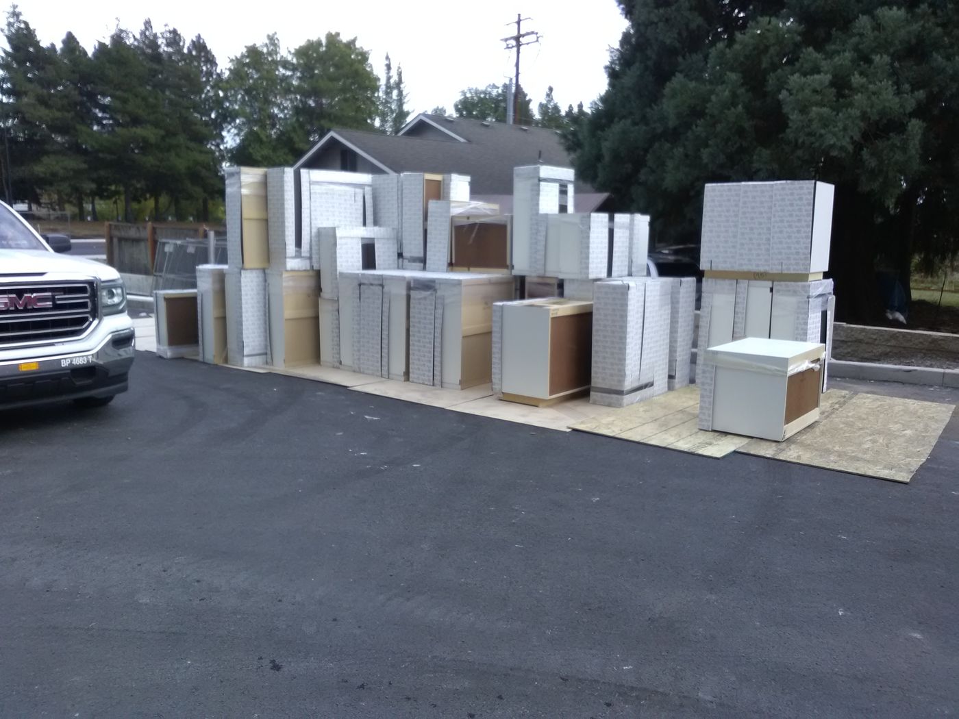 Rows of new cabinets staged on a parking lot for a commercial delivery